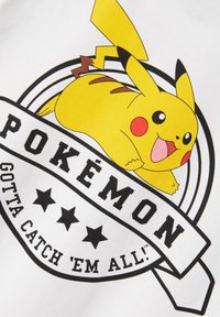 Diseño de un personaje Pokémon amarillo que presenta a Pikachu, sobre un fondo blanco. Incluye acentos circulares negros y texto que dice "POKÉMON" y "TENGO QUE ATRAPARLOS A TODOS."
