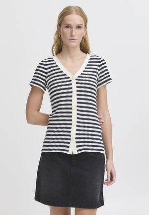 Haut à manches courtes rayé en bleu marine et blanc avec un col en V et un devant boutonné. Porté avec une jupe en denim noire, présentant une finition texturée.