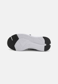 Svart-hvitt sneakersåle med teksturert gummi og et karakteristisk mønster samt logodetalj i midten. Tykk polstring er avbildet.