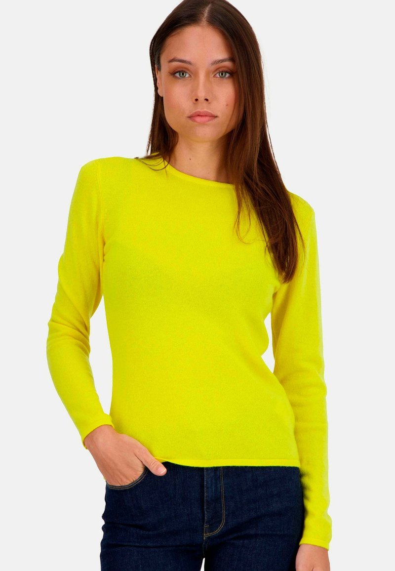 Long-sleeve, crew-neck sweater in bright yellow, ribbed texture, paired with dark blue jeans. No visible patterns or hardware details.