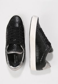 Sneaker neri con un motivo in pelle di serpente testurizzata, dotati di lacci neri, un tallone con accento argentato e una suola in gomma bianca.