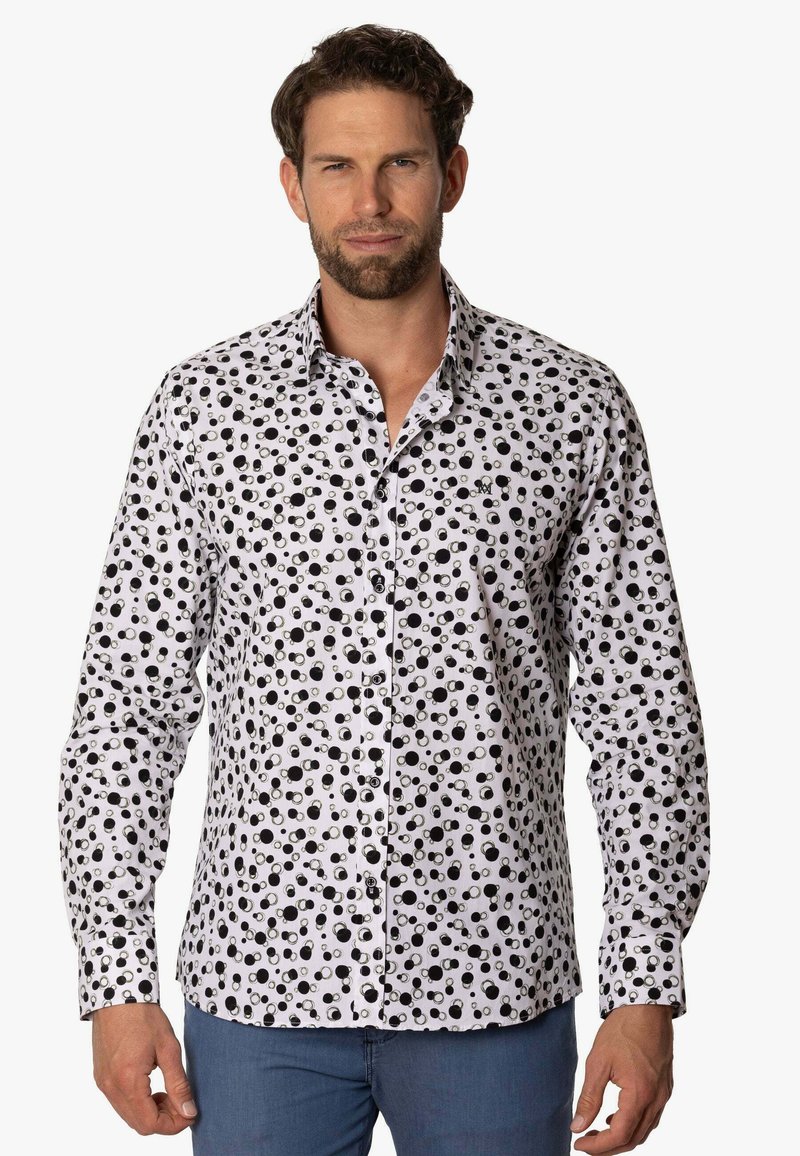 Camisa blanca con un patrón circular negro, cuello abotonado, corte ajustado y mangas largas. Tejido suave con botones en contraste.