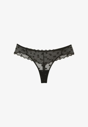Black mesh thong with polka dot pattern, scalloped edges, and a classic cut. Features a sheer texture and contrasting solid waistband.