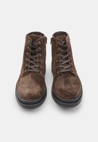 Botas de ante marrón hasta el tobillo con cordones y cremallera lateral. Suela de goma plana con detalles texturizados. La parte superior presenta un acabado suave.