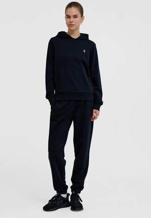 Mørkeblå hættetrøje med en frontlomme og et lille logo på brystet, parret med matchende joggingbukser og sorte sportsko.