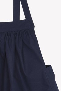 Mørkeblå bomulls totebag med rynket design, to skulderstropper og en sidelomme for oppbevaring, med en glatt overflate.