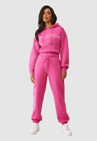 Roze hoodie en bijpassende sweatpants set, met verstelbare trekkoorden en bedrukte logodetails, gemaakt van zachte katoenmix.
