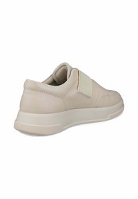 Beige sneaker med tekstureret læderoverdel, elastisk rem, polstret krave og gummisål. Rundet form med kontrastsyede detaljer.
