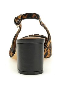 Sandaal met hoge hak in luipaardprint, zwarte blokhak, verstelbare enkelband en een getextureerd bovenwerk van textiel. Opvallende patroondetails.