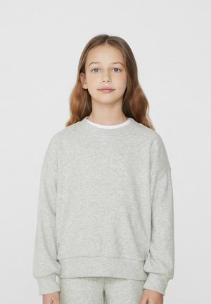 Světle šedá mikina vyrobená z měkké, strukturované látky, s kulatým výstřihem a volným střihem. Manžety a spodní lem jsou mírně elastické.