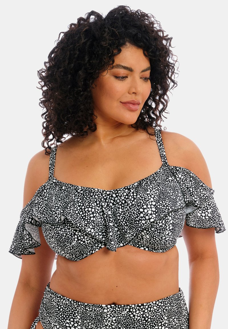 Haut de bikini à pois noir et blanc avec des manches volantées et une conception structurée. Comprend des bretelles réglables et un soutien-gorge avec armatures.