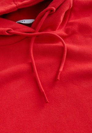 Röd hoodie med en mjuk textur, som har en dragsko vid halsen, och en slät yta. Tyget ser varmt och bekvämt ut.