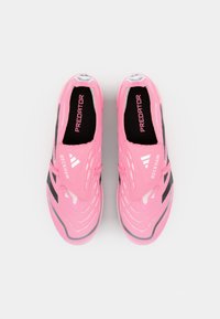 Roze voetbalschoenen met een slank ontwerp, voorzien van textuur op de bovenkant en zwarte accenten. Een band bedekt de veters, met "PREDATOR" branding.