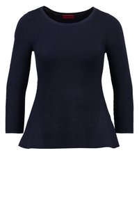 Pull en maille côtelée bleu marine avec manches trois-quarts et ourlet évasé, doté d'un col rond. Détail de tissu texturé visible.