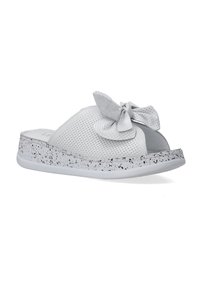 Witte instapsandalen met geperforeerde bovenkant, decoratieve strik en gespikkelde zool. Plat ontwerp, synthetisch materiaal, open teen.