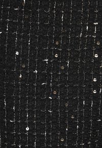 Material negru texturat cu cusături albe orizontale și paiete aurii împrăștiate. Modelul adaugă profunzime printr-un aspect structurat.