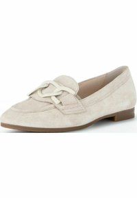 Beige suede loafers with a low heel, featuring a decorative cream-colored chain accent on the front and a smooth interior lining.