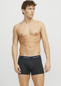 Zwarte boxershorts met een strakke pasvorm, voorzien van een contrasterende elastische tailleband met het label "Originals Studio." Gladde stoftextuur.