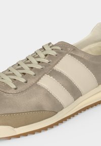 Μπεζ και εκρού σουέντ αθλητικό παπούτσι με λευκά κορδόνια, ραμμένες ρίγες στο πλάι και αυλακωτή ανοιχτό καφέ σόλα.