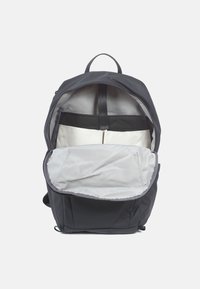 Sac à dos noir avec un intérieur spacieux et gris, doté d'une poignée supérieure, de deux compartiments et d'un design simple et utilitaire.