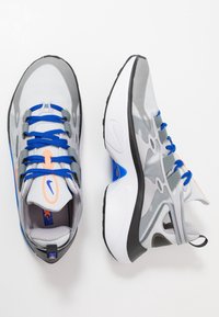 Graue Sportschuhe mit blauen Schnürsenkeln und orangefarbenen Akzenten. Mesh-Obermaterial mit strukturiertem Muster, gepolsterte Sohle und schwarze Gummiaußensohle.