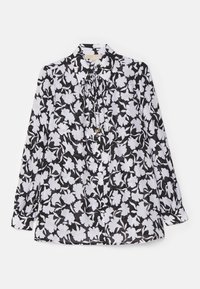 Blusa en blanco y negro con un estampado floral, mangas largas, cuello y un detalle de lazo en el escote. Tejido suave y ligero.