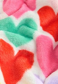 Fuzzy blanket featuring large heart patterns in red, pink, and mint on a white background, showcasing a soft, textured surface.