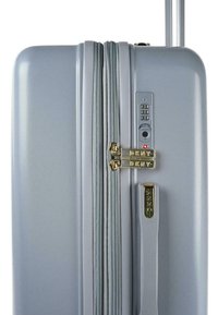 Maleta rígida gris con un acabado texturizado, dos cremalleras doradas, cerradura combinada y un asa retráctil para un transporte fácil.