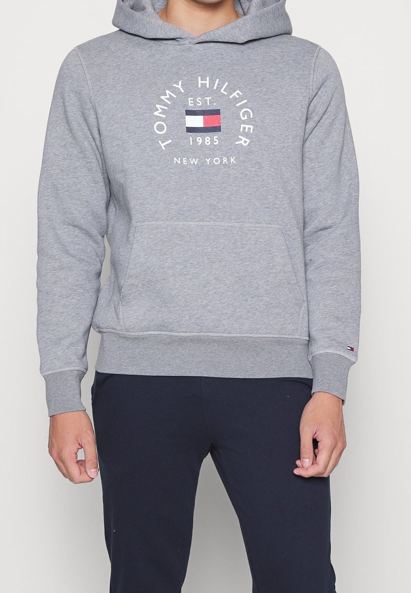 Grauer Hoodie aus Strickstoff, mit einer Fronttasche, gerippten Bündchen und dem "Tommy Hilfiger"-Logo mit mehrfarbigen Akzenten.