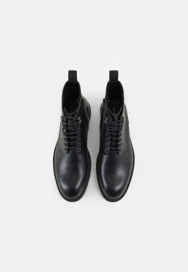 Zwarte leren enkellaarzen met een gladde textuur, vetersluiting aan de voorkant en een zijrits. Voorzien van een lusvormige trekriem aan de achterkant en een ronde neus.