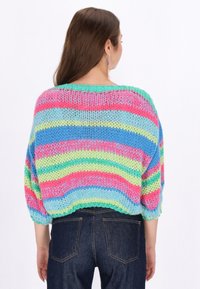 Maglione lavorato a maglia con righe orizzontali in rosa, verde, blu e viola. Vestibilità ampia con maniche a ¾ e scollo rotondo ampio.