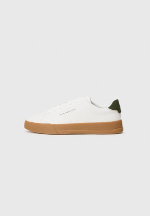Valge madala lõikega tenniseking, millel on pruun kummitald, roheline kontsakupar ja „Tommy Hilfiger“ logo külgedel.