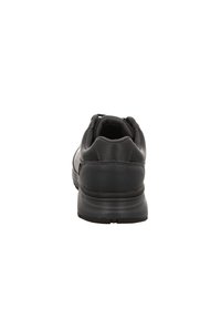 Zapatilla deportiva negra con un collarín acolchado y parte superior de malla. Presenta una suela de goma texturizada y un talón reforzado para mayor apoyo.