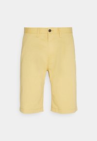 Pantaloni corti di cotone gialli con una vestibilità dritta, orlo risvoltato e chiusura con un solo bottone in vita. Tessuto liscio senza disegni.