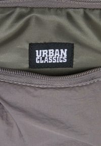 Gray fabric interior with a black label reading "URBAN CLASSICS" in white. Features a zipper along the edge and a smooth texture.