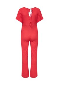 Červený pletený overal s krátkými rukávy, zadním průstřihem na zavazování na mašli a mírně rozšířenými nohavicemi na celou délku.