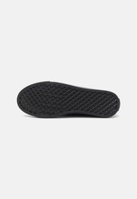 Black rubber shoe sole with a textured geometric pattern, featuring a smooth edge and slight curvature for comfort and durability.