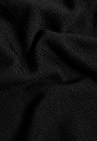 Tessuto nero con una trama strutturata, che mostra pieghe e grinze, evidenziando le qualità morbide e flessibili.
