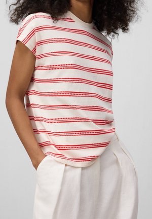 Camiseta de manga corta color crema con rayas horizontales rojas. Material de algodón suave, corte relajado, cuello redondeado y un sutil detalle de bolsillo.