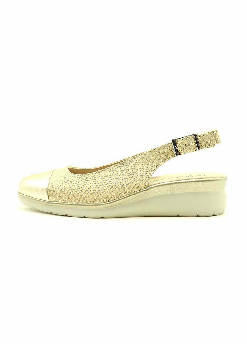 Sandalia cuña tipo slingback en crema. Presenta un upper de malla texturizada, punta metálica y un cierre de hebilla ajustable. Tacón cuña para mayor soporte.