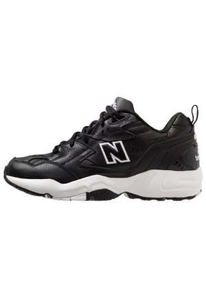 Zwarte New Balance sneaker met witte tussenzool, veters aan de voorkant en merklogo aan de zijkant, gezien vanaf de binnenkant.