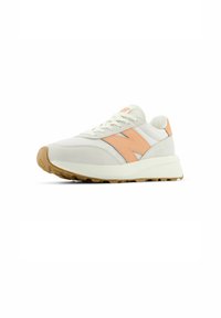 Sneaker bianca con accenti arancioni chiari e suola in gomma. Presenta una tomaia in rete e suede, punta rotonda e lacci piatti.