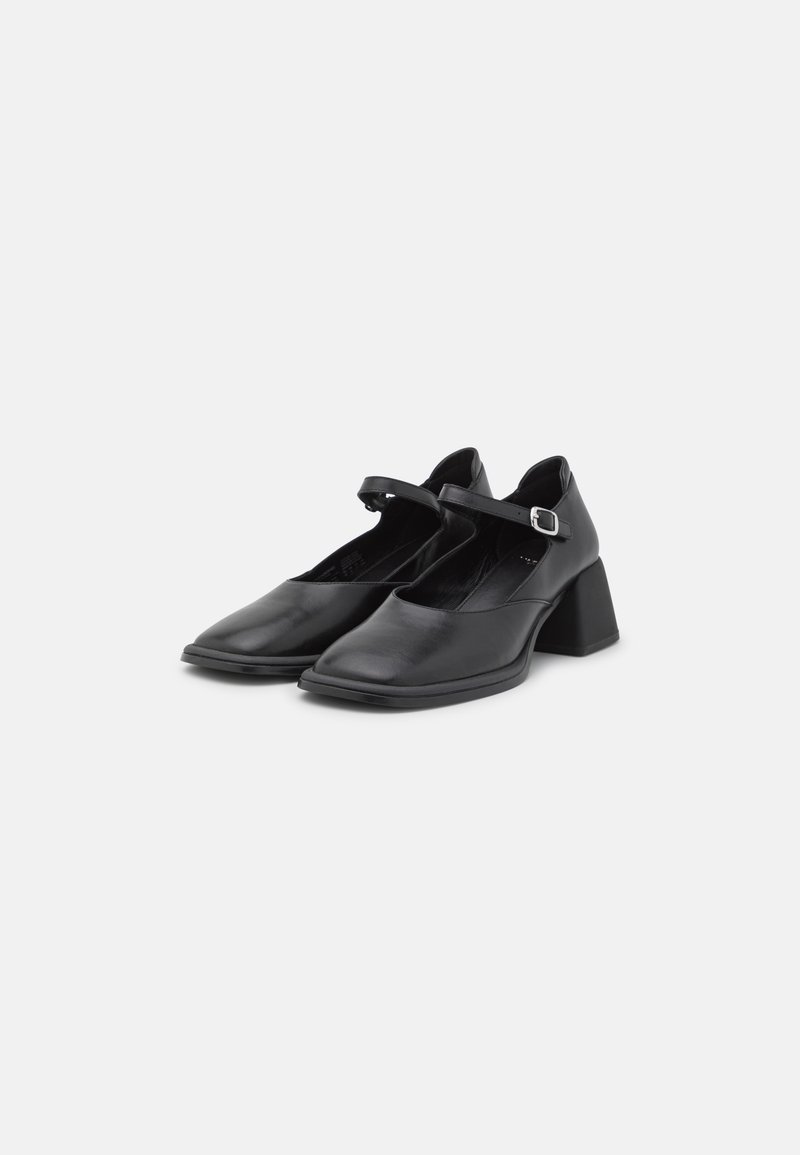 Chaussures noires en cuir Mary Jane avec des bouts carrés, des sangles à boucle réglables et des talons bas en bloc sur un fond blanc.