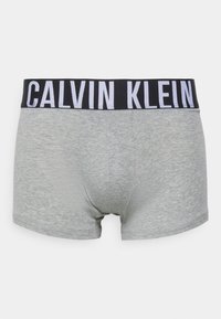 Pelēki kokvilnas bokseri ar melnu elastīgu jostasvietu, uz kuras ir izdrukāti "CALVIN KLEIN" balti burti. Mīksta tekstūra un cieša pieguļamība.
