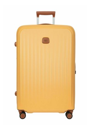 Gelber Hartschalen-Trolley mit Teleskopgriff und vier Rollen mit 360-Grad-Drehung, braune Akzente am Griff und an den Rädern.