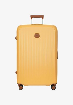 Valigia rigida gialla con manico telescopico e quattro ruote girevoli, dettagli marroni su manico e ruote.