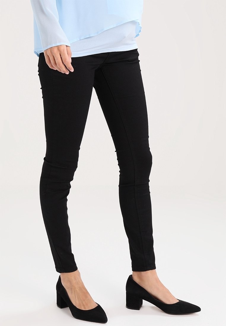 Black skinny jeans, stretchy fabric, mid-rise waist, seamless design. Paired with black suede pointed-toe heels. Light blue top.