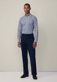 Blue and white checkered button-down shirt paired with dark navy pants and black dress shoes, featuring a classic collar and full sleeves.