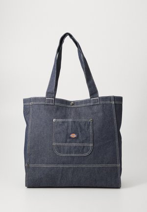 Saco de lona de ganga com duas alças robustas, cor azul escura, costura branca, um bolso frontal e um pequeno emblema logo na parte superior.