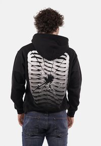Felpa nera con cappuccio con un design grafico di ossa costali e un motivo crepato sulla schiena, realizzata in tessuto morbido.